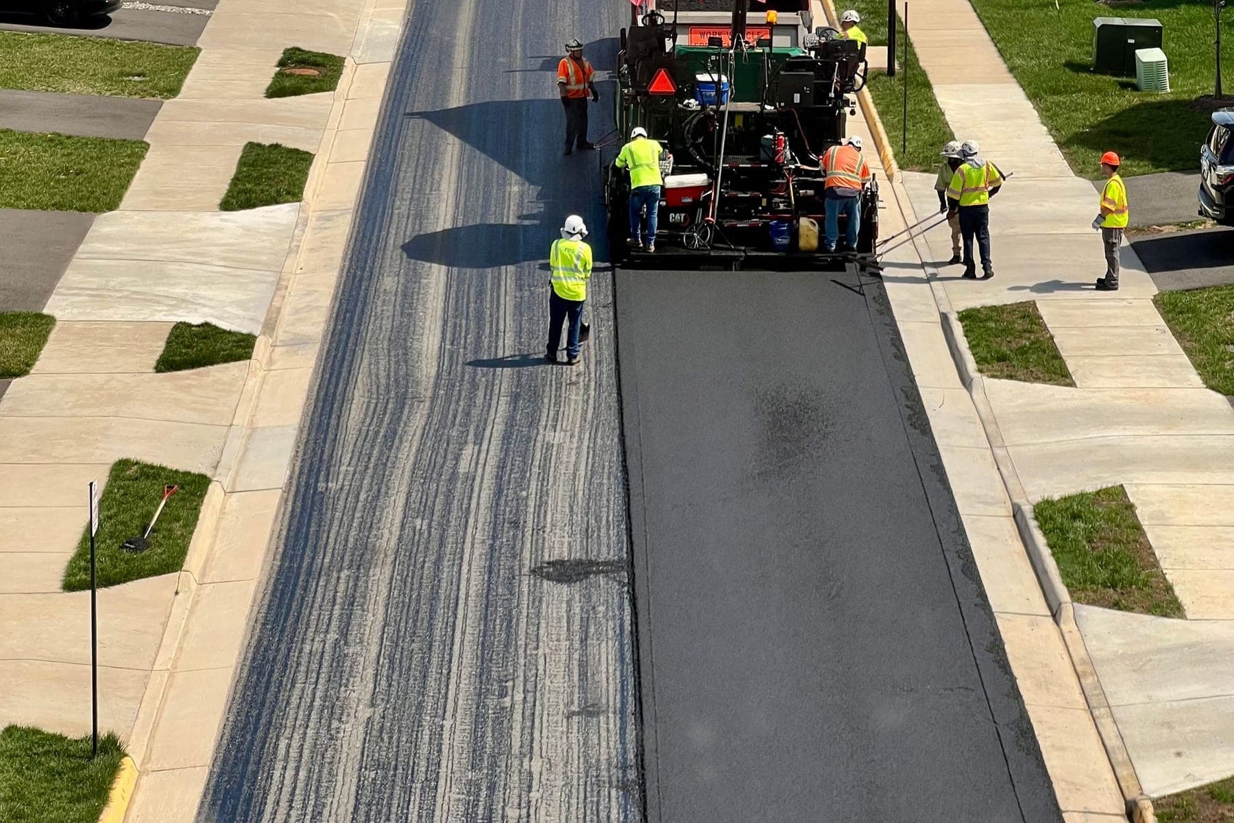 Crew repaving a residential street in a suburban neighborhood
