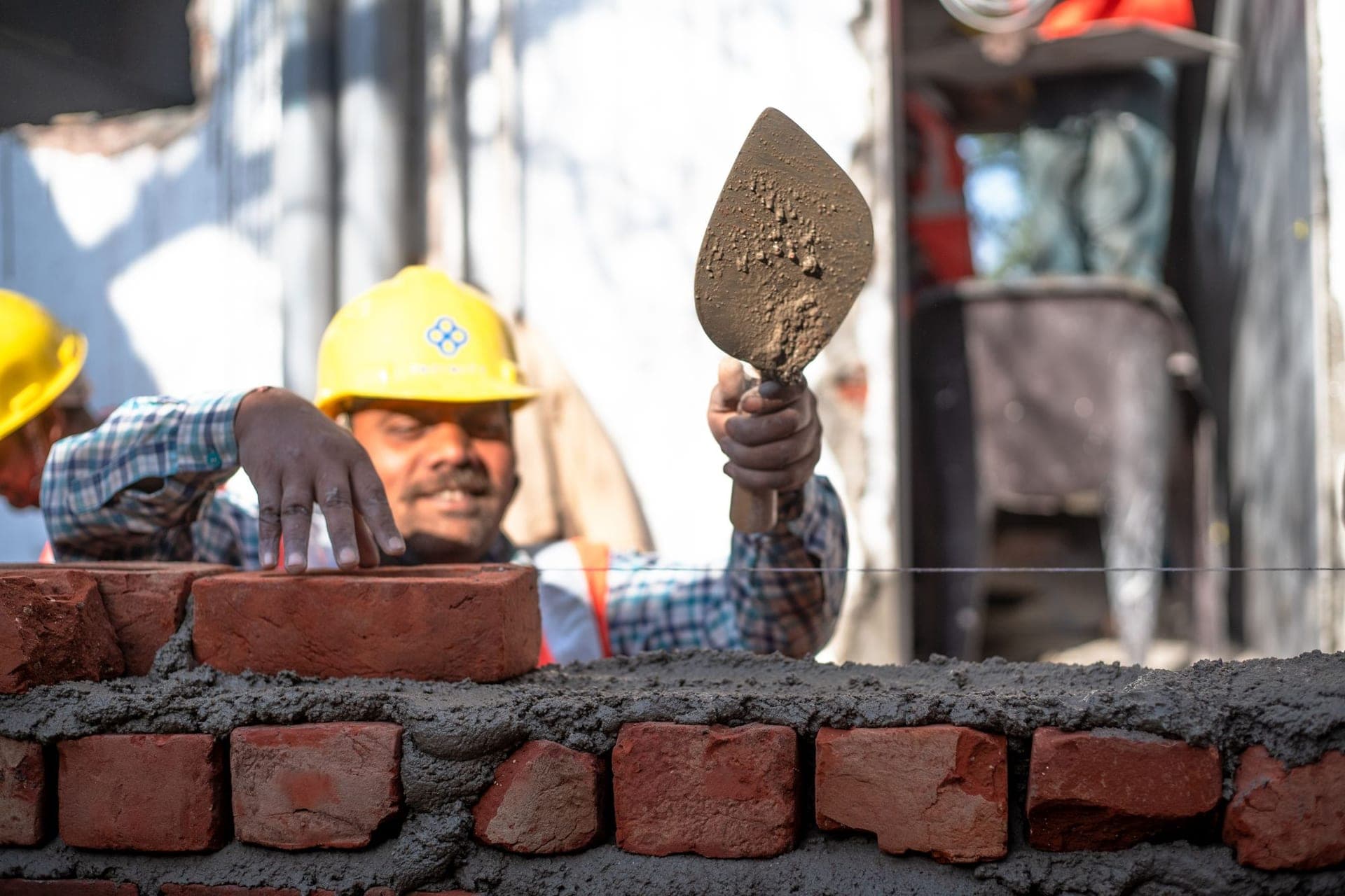 Bricklayer setting bricks in fresh mortar